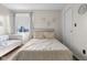 Bright bedroom featuring a beige bed, white couch, hardwood floors, and a neutral color scheme at 4605 Clairmont Dr, Columbus, IN 47203