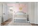 Charming Bedroom featuring a crib against a soft pink wall, adorned with decorative elements at 4605 Clairmont Dr, Columbus, IN 47203