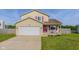Inviting home featuring a red front door, a two-car garage, a delightful front porch, and lush green lawn at 4605 Clairmont Dr, Columbus, IN 47203