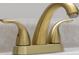 Close-up of a stylish gold bathroom faucet with a three-handle design at 4605 Clairmont Dr, Columbus, IN 47203