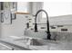 Close up of kitchen sink with a black, industrial style faucet and neutral backsplash at 4605 Clairmont Dr, Columbus, IN 47203