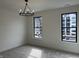 Carpeted bedroom with modern light fixture and two large windows allowing lots of natural light at 473 Mariposa Trl, Carmel, IN 46032