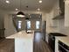 Modern kitchen features stainless steel appliances, white cabinets, and a central island with pendant lighting at 473 Mariposa Trl, Carmel, IN 46032