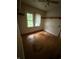 Small bedroom with hardwood floors, a window, and wall shelving at 4931 Orion Ave, Indianapolis, IN 46201