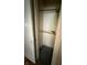 A closet with aged walls, a gray floor and a wooden rod for hanging clothing at 4931 Orion Ave, Indianapolis, IN 46201