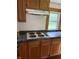 Kitchen with oak cabinets, cooktop, and dark countertops at 4931 Orion Ave, Indianapolis, IN 46201
