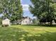 Large backyard with mature trees, storage shed, ATV, hot tub, and fire pit at 530 Denny Dr, Mooresville, IN 46158