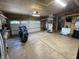 Well-lit garage with a motorcycle parked in front of a closed garage door, also with a large work space at 530 Denny Dr, Mooresville, IN 46158
