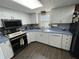 Well-lit kitchen with white cabinetry, blue countertops, and modern black stainless steel appliances at 530 Denny Dr, Mooresville, IN 46158