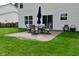 A brick patio includes a table, an umbrella and chairs looking onto the backyard and home at 5456 Reston Dr, Plainfield, IN 46168