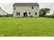 Large green backyard with trees, a wooden fence, and a brick patio with a table, an umbrella, and chairs at 5456 Reston Dr, Plainfield, IN 46168