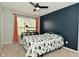 Bright bedroom features a ceiling fan, a window with natural light, and a dinosaur-themed bedspread at 5456 Reston Dr, Plainfield, IN 46168