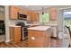 Well-lit kitchen features wooden cabinets, stainless steel appliances, island, and access to the backyard at 5456 Reston Dr, Plainfield, IN 46168