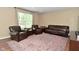 A spacious living room with brown leather furniture, an area rug, and a large window at 5456 Reston Dr, Plainfield, IN 46168
