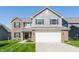 Two-story home featuring a two-car garage, brick accents, and a well-manicured lawn at 5794 Cherrywood Ln, McCordsville, IN 46055