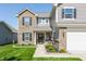 Charming two-story home with a welcoming entrance, brick accents, and professional landscaping at 5794 Cherrywood Ln, McCordsville, IN 46055