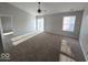 Spacious living room features a ceiling fan, window, and sliding glass doors at 5825 Sapelo Dr, Indianapolis, IN 46237