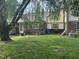 A charming backyard features a lush lawn, brick accents, and a large tree adding to the outdoor scenery at 5941 Deerwood Ct, Indianapolis, IN 46254