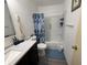 This bathroom features a vanity with sink, toilet, and shower with blue shower curtain at 5941 Deerwood Ct, Indianapolis, IN 46254