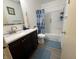 This bathroom features a vanity with sink, toilet, and shower with blue shower curtain at 5941 Deerwood Ct, Indianapolis, IN 46254