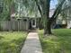 A quaint front yard showcases a walkway leading to the front door, with a mature tree enhancing the curb appeal at 5941 Deerwood Ct, Indianapolis, IN 46254