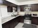 Well-lit kitchen with dark wood cabinets, stainless steel appliances, and white marble countertops for a sleek and functional space at 5941 Deerwood Ct, Indianapolis, IN 46254