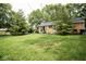 Large backyard with grass, trees, and rear exterior of single-story house at 6180 Winnpeny Ln, Indianapolis, IN 46220
