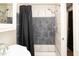 Tiled bathroom shower with black shower curtain, sink, and vanity at 6180 Winnpeny Ln, Indianapolis, IN 46220