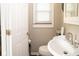 Cozy bathroom with a pedestal sink, white walls, and a window, offering a clean and functional space at 6180 Winnpeny Ln, Indianapolis, IN 46220
