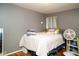 Bedroom features gray walls, hardwood floors, a bed with plush toys, and fan creating space at 6180 Winnpeny Ln, Indianapolis, IN 46220