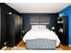 Modern bedroom features a bed with a tufted footboard, dark furniture, wood floors, and stylish decor at 6180 Winnpeny Ln, Indianapolis, IN 46220