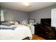 Bedroom features gray walls and hardwood floors, furnished with a bed, dresser, desk, and window at 6180 Winnpeny Ln, Indianapolis, IN 46220