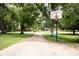 Long driveway featuring a basketball hoop and lots of trees at 6180 Winnpeny Ln, Indianapolis, IN 46220