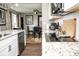 Kitchen with white cabinets, granite countertops, stainless steel appliances, and dining area in the background at 6180 Winnpeny Ln, Indianapolis, IN 46220