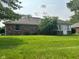 Spacious backyard featuring a well-maintained lawn, mature trees, and a brick home with a screened patio at 641 S Grant St, Brownsburg, IN 46112