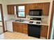 Functional kitchen with a double sink, gas range, microwave, and wooden cabinetry at 641 S Grant St, Brownsburg, IN 46112