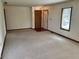 Large living room with neutral carpet, front door entrance, and closet at 641 S Grant St, Brownsburg, IN 46112