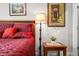 Well-decorated bedroom featuring red bedding, a lamp, and a small side table at 655 N Sobota Way, Trafalgar, IN 46181