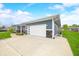 Exterior showing concrete driveway, two car garage, stone accents, and blue siding at 655 N Sobota Way, Trafalgar, IN 46181
