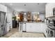 Open kitchen with stainless steel appliances, granite counters, and an adjacent living area at 655 N Sobota Way, Trafalgar, IN 46181