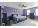 Inviting primary bedroom with purple walls, ceiling fan, and plush carpet at 6608 Sonesta Dr, Indianapolis, IN 46217