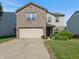 Charming two-story home featuring a brick facade, attached garage, and manicured front yard at 6608 Sonesta Dr, Indianapolis, IN 46217