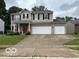 Charming two-story home with a two-car garage and a well-manicured lawn at 6730 Nw Shanghai Cir, Indianapolis, IN 46268
