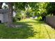 Lush backyard featuring mature trees, green grass, and partial fencing at 6801 Shalimar Ct, Indianapolis, IN 46214