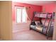Pink bedroom showcasing a bunk bed, a window, and carpeted floors at 6801 Shalimar Ct, Indianapolis, IN 46214