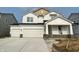 New construction two-story home boasting a three car garage, white siding, and contrasting stone foundation at 7151 Firestone Rd, Whitestown, IN 46052