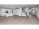 Open concept living area with wood-look floors, staircase, and all-white kitchen at 7151 Firestone Rd, Whitestown, IN 46052