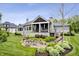 Stone patio with seating and landscaped backyard featuring a covered porch with stone fireplace at 780 Chatham Hills Blvd, Westfield, IN 46074
