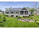 Expansive backyard featuring a covered porch with seating and a stone patio with a fire pit at 780 Chatham Hills Blvd, Westfield, IN 46074