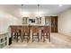 This home bar features seating for four, glass-front cabinets, and a sliding barn door adding rustic charm at 780 Chatham Hills Blvd, Westfield, IN 46074